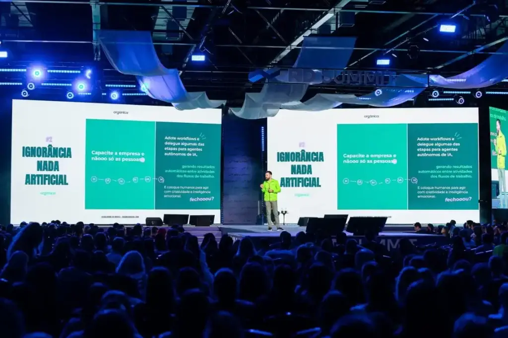 Orgânica Digital no palco durante palestra sobre Ignorância nada Artificial.